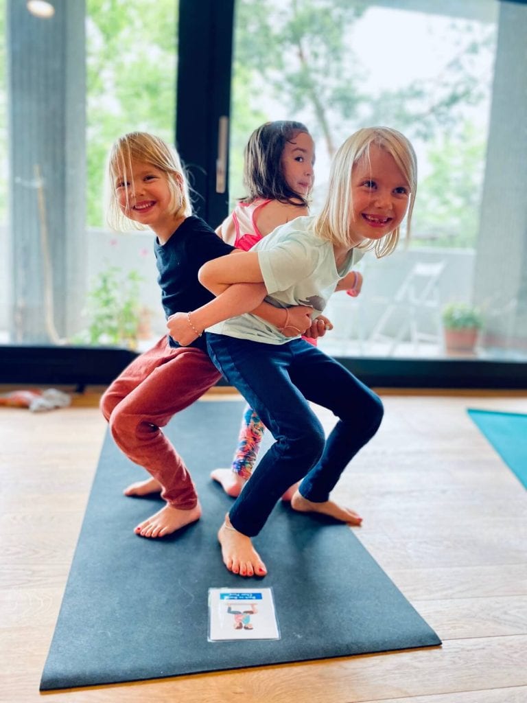 3 little girls doing the chair pose back to back