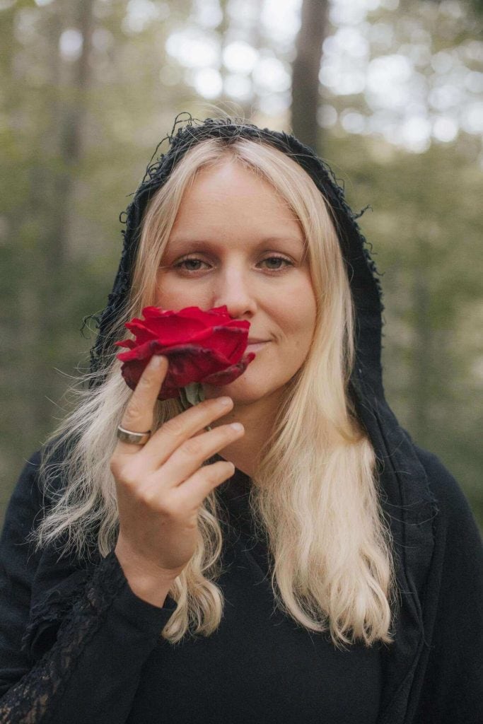 Caroline smelling a rose.